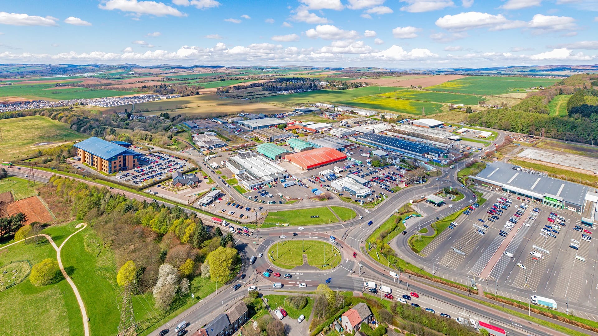 Aerial view of Wester Gourdie Industrial Estate in Dundee showing roundabout access and surrounding retail and industrial units