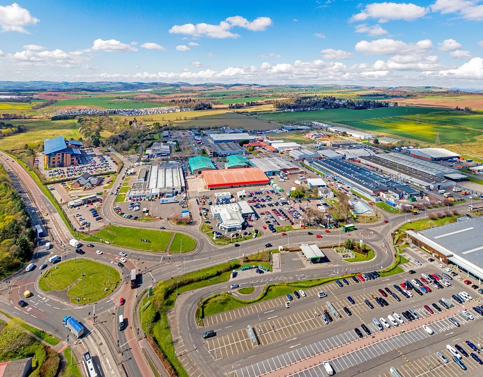 Aerial view of Wester Gourdie Industrial Estate in Dundee showing roundabout, retail units and surrounding commercial area